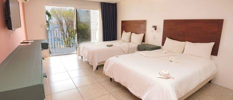 A hotel room with two beds, a TV, and a balcony with a view.