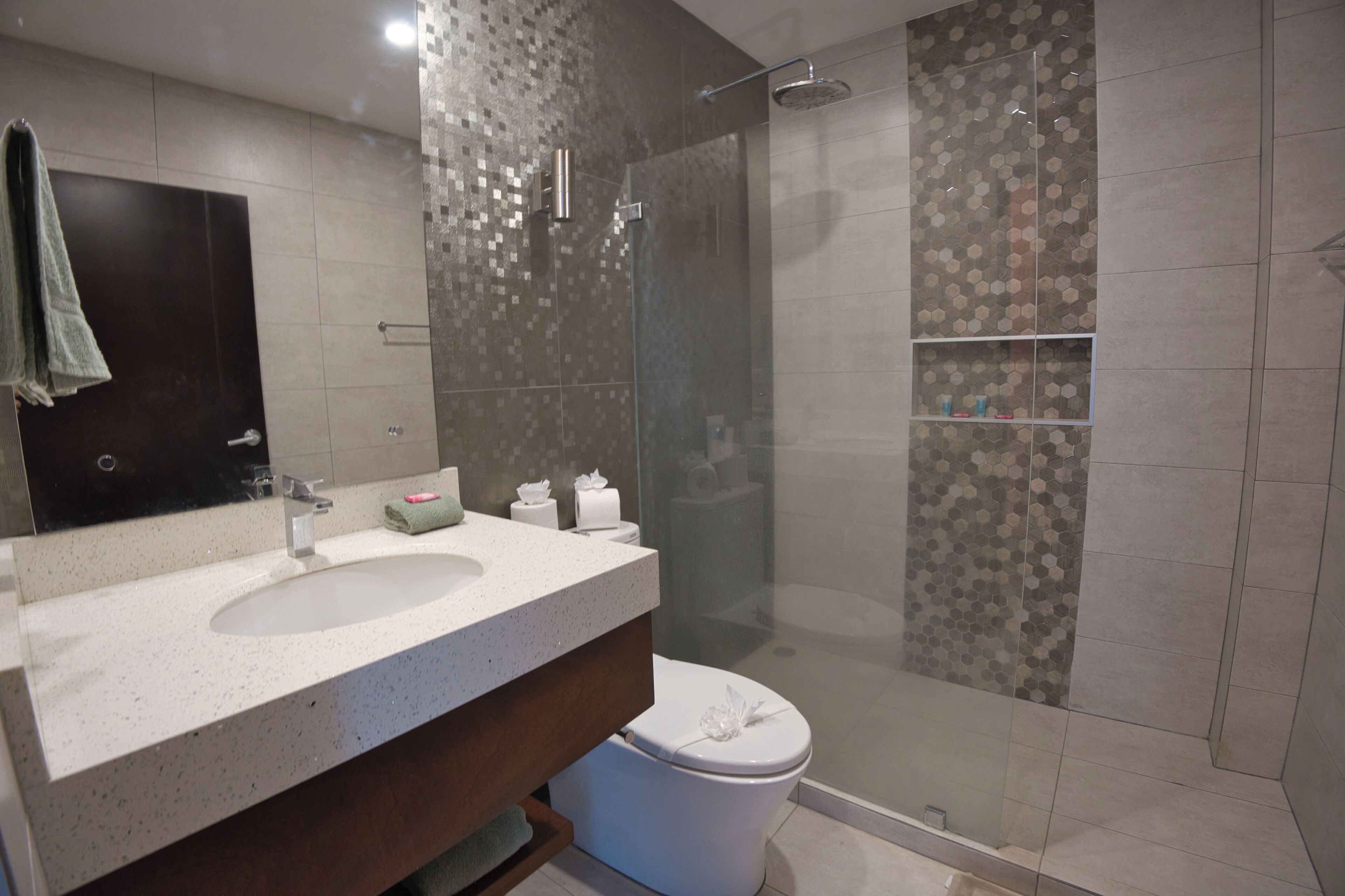 Une salle de bain moderne avec un grand lavabo, un miroir et une douche à parois de verre.