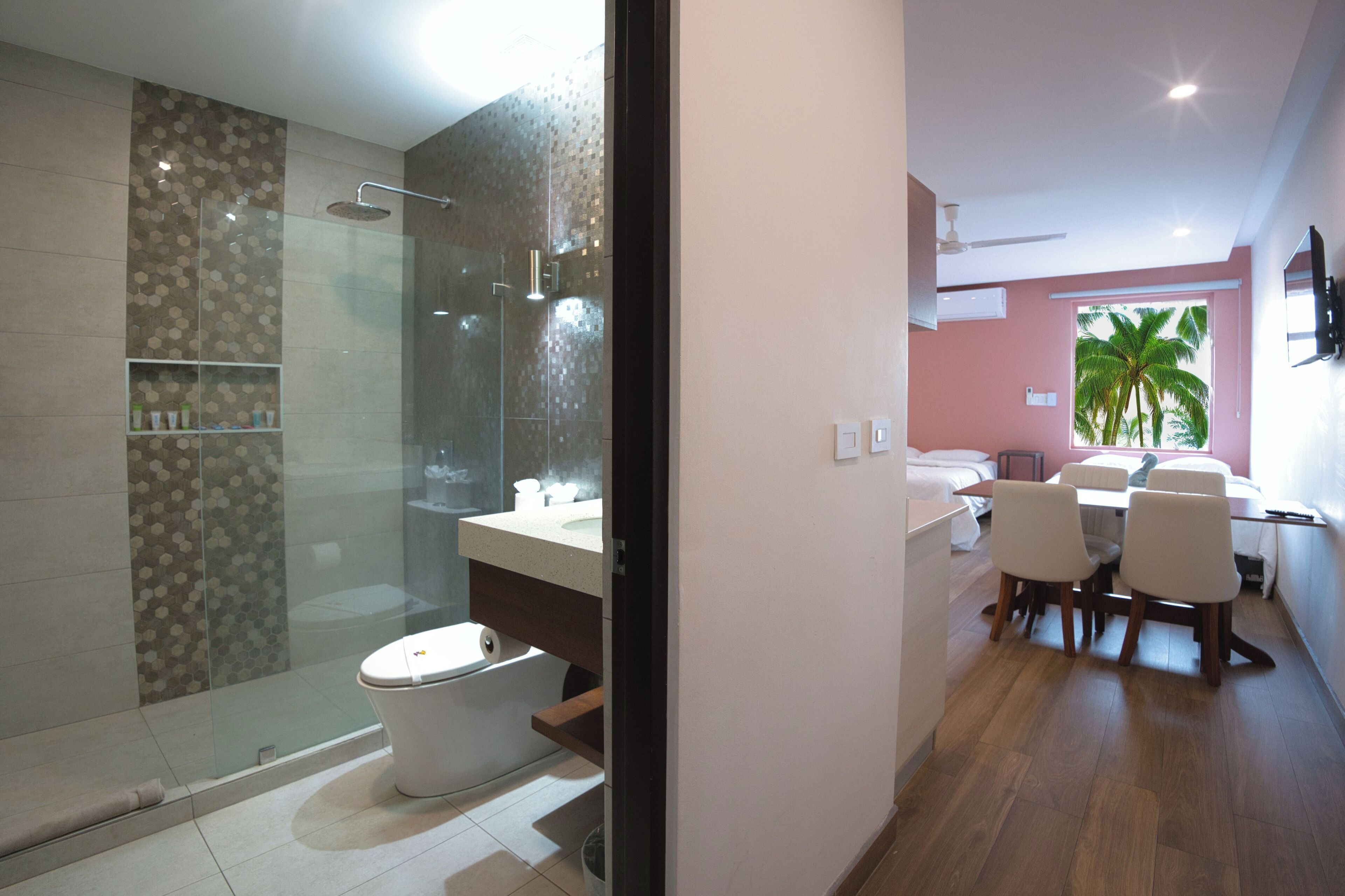 Ein modernes Badezimmer mit Duschkabine aus Glas, Toilette und Waschtisch.