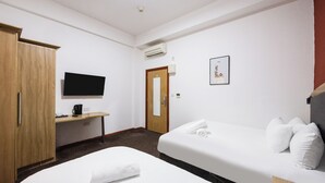 A hotel room with two beds, a wooden wardrobe, a desk with a flat-screen TV, and a framed picture on the wall. - Arinza Hotel, London Ilford (Ilford)