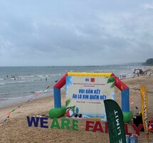 Una playa con una estructura inflable de colores y un cartel.