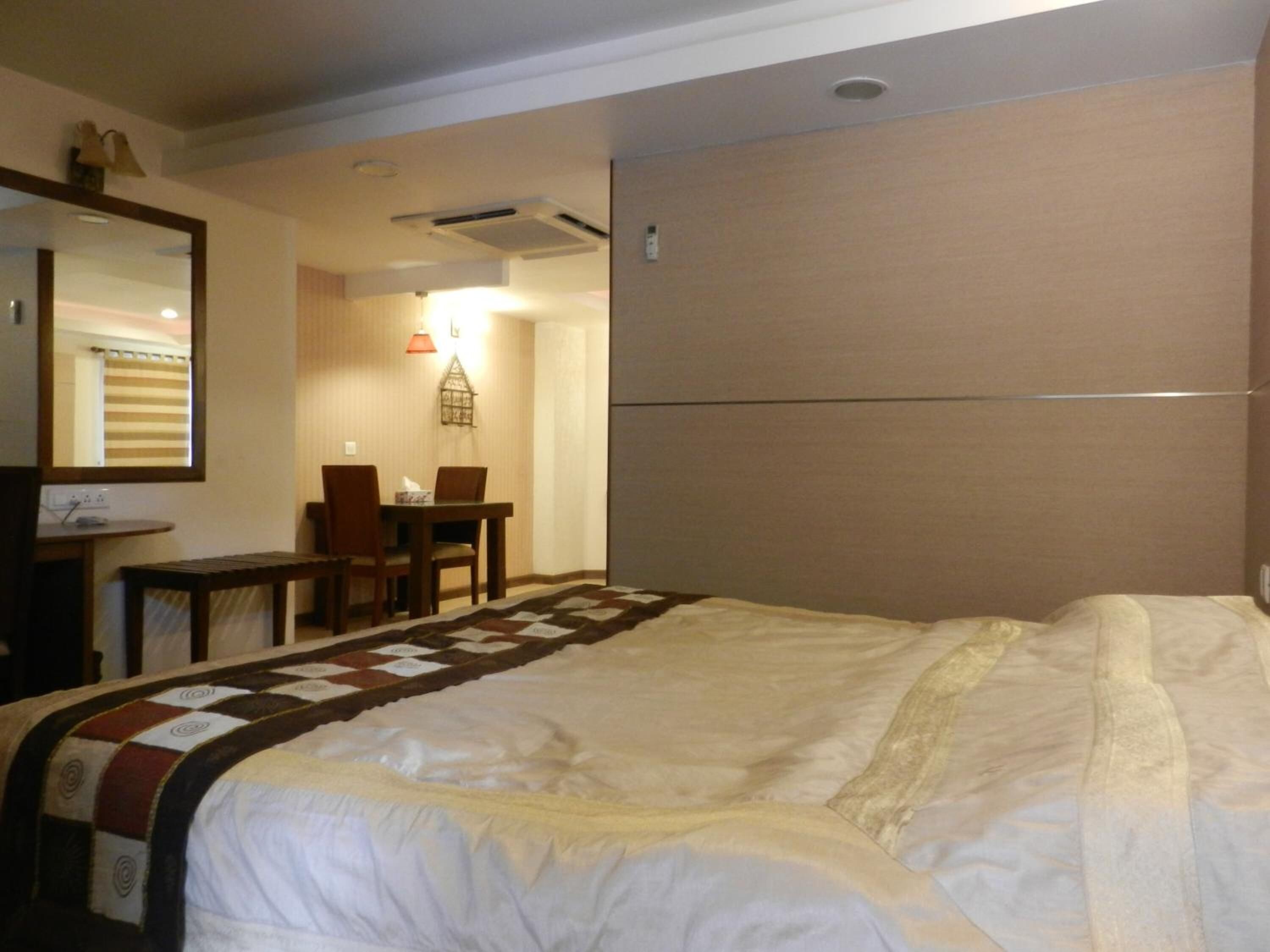 Habitació d'hotel amb un llit, una taula i una cadira.