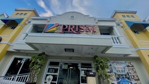 A building with a sign reading "PRISM" and a colorful logo. - Prism Hotel (Angeles City)