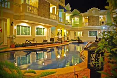 Una piscina al aire libre, sillones reclinables de piscina