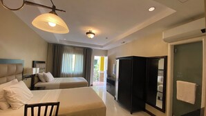 A hotel room with two beds, a desk, a wardrobe, and a bathroom. - Prism Hotel (Angeles City)