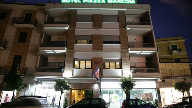 A multi-story hotel with balconies, a flag, and a sign reading "HOTEL PIAZZA MARCONI". - Hotel Piazza Marconi (Cassino)