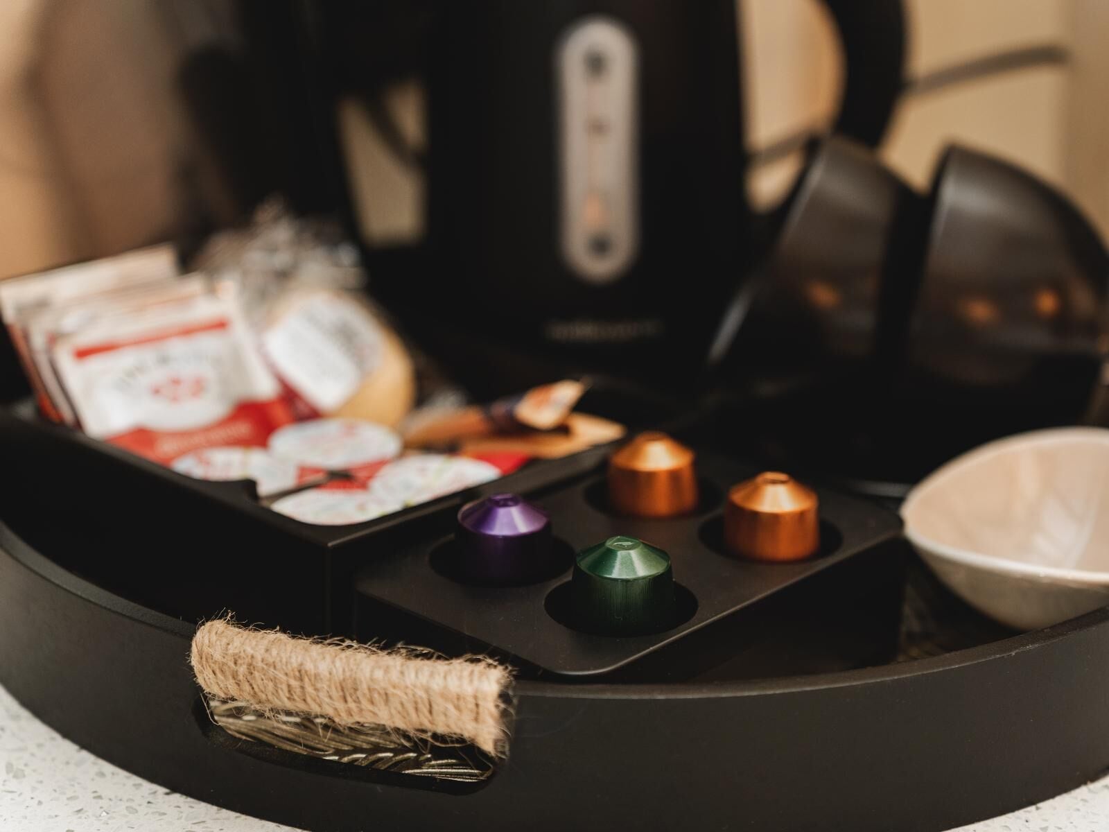 Eine Küchenzeile mit einer Kaffeemaschine, einem Wasserkocher und einem Kaffeeautomaten.