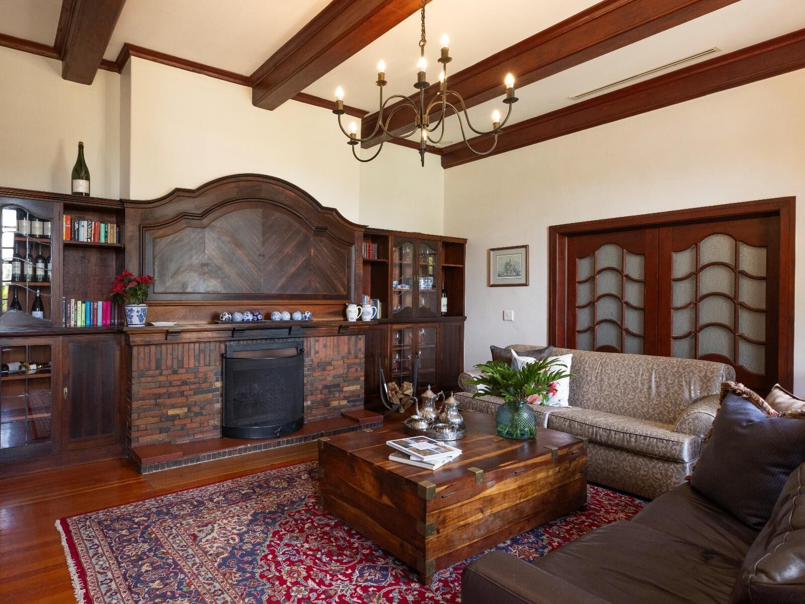 Una sala de estar con chimenea, estanterías, un sofá y una mesa de centro.