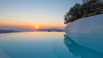 Una piscina infinita tranquila con vistas despejadas al atardecer y montañas lejanas.