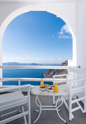 A white balcony with a table and chairs, overlooking a clear blue sea and distant mountains. - Helestia Pocket Hotel, Caldera Santorini (Santorini)