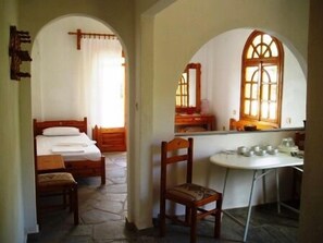 Traditional room with a bed, dining table, and mirror.