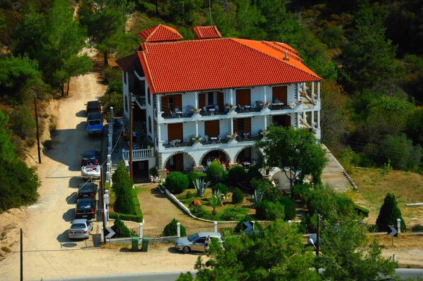 Situated on a wooded hillside, this two-story building features a central courtyard with a fountain and lush greenery.