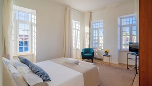 A hotel room with a large bed, a desk, a chair, and a TV. - Hotel Farol (Ilhavo)