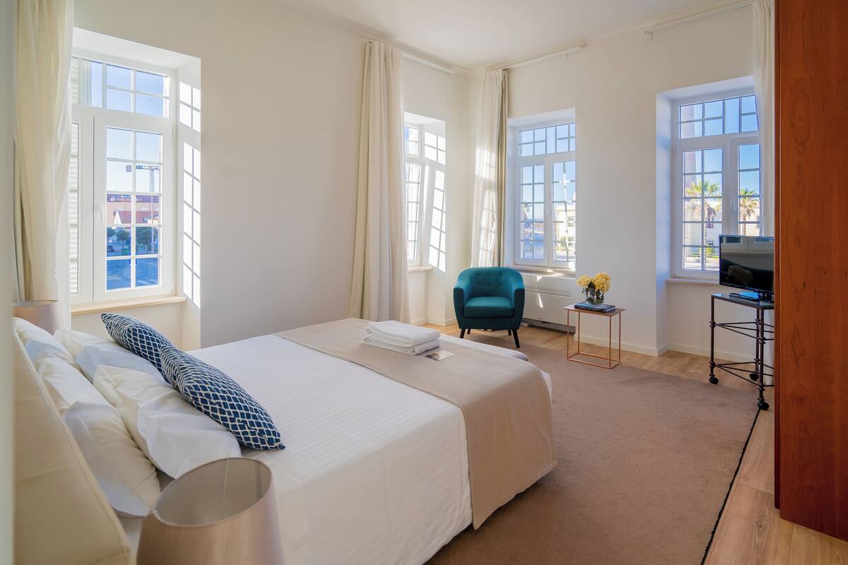 Une chambre d’hôtel avec un grand lit, un bureau, une chaise et un téléviseur.