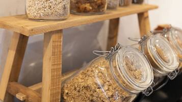 Una estantería de madera con varios frascos de vidrio que contienen diferentes alimentos.