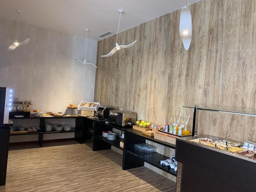 A modern breakfast area with wooden walls, a buffet counter, and hanging pendant lights.