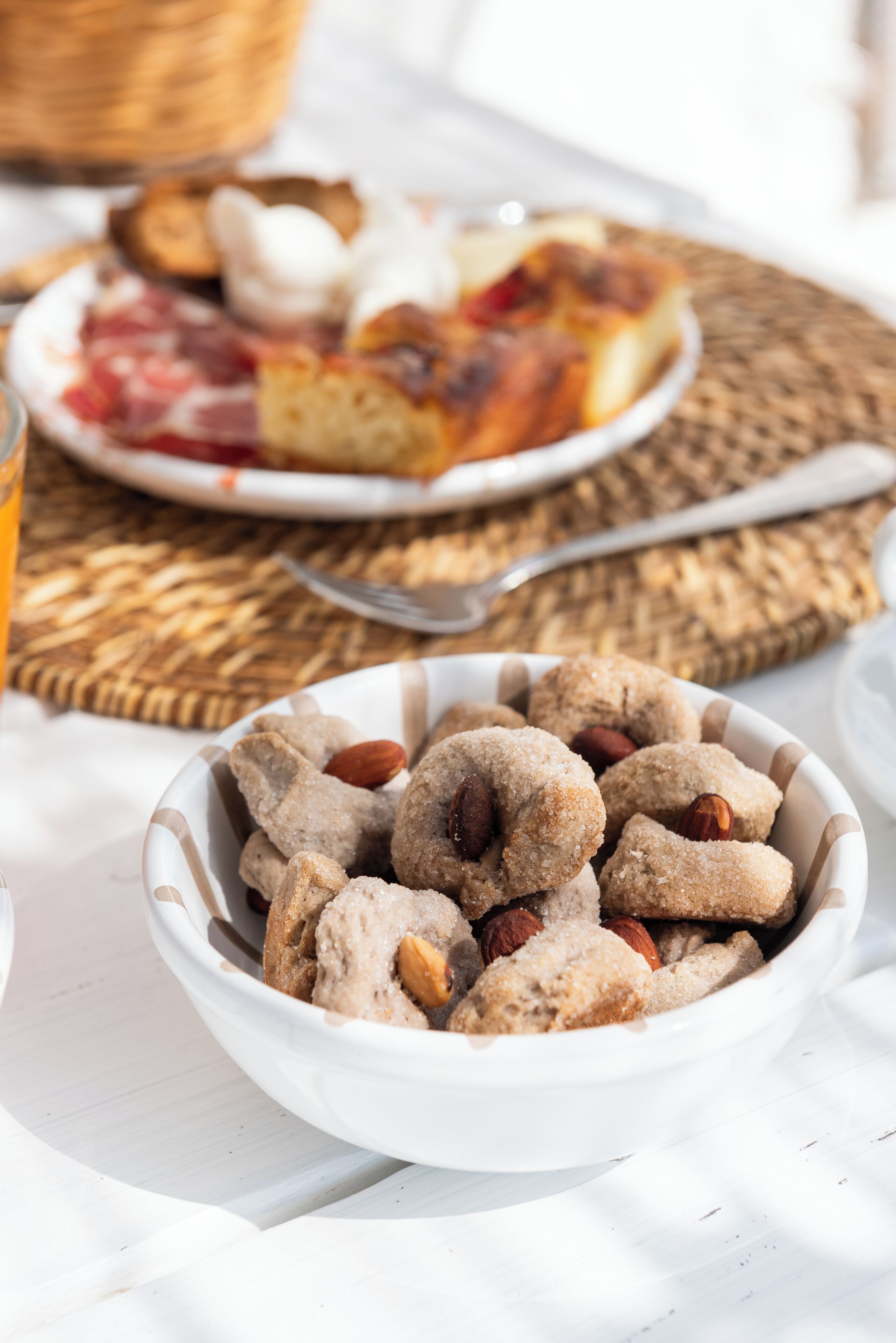 Eine Schüssel mit Nussecken, ein Teller Brot und ein Korb im Hintergrund.