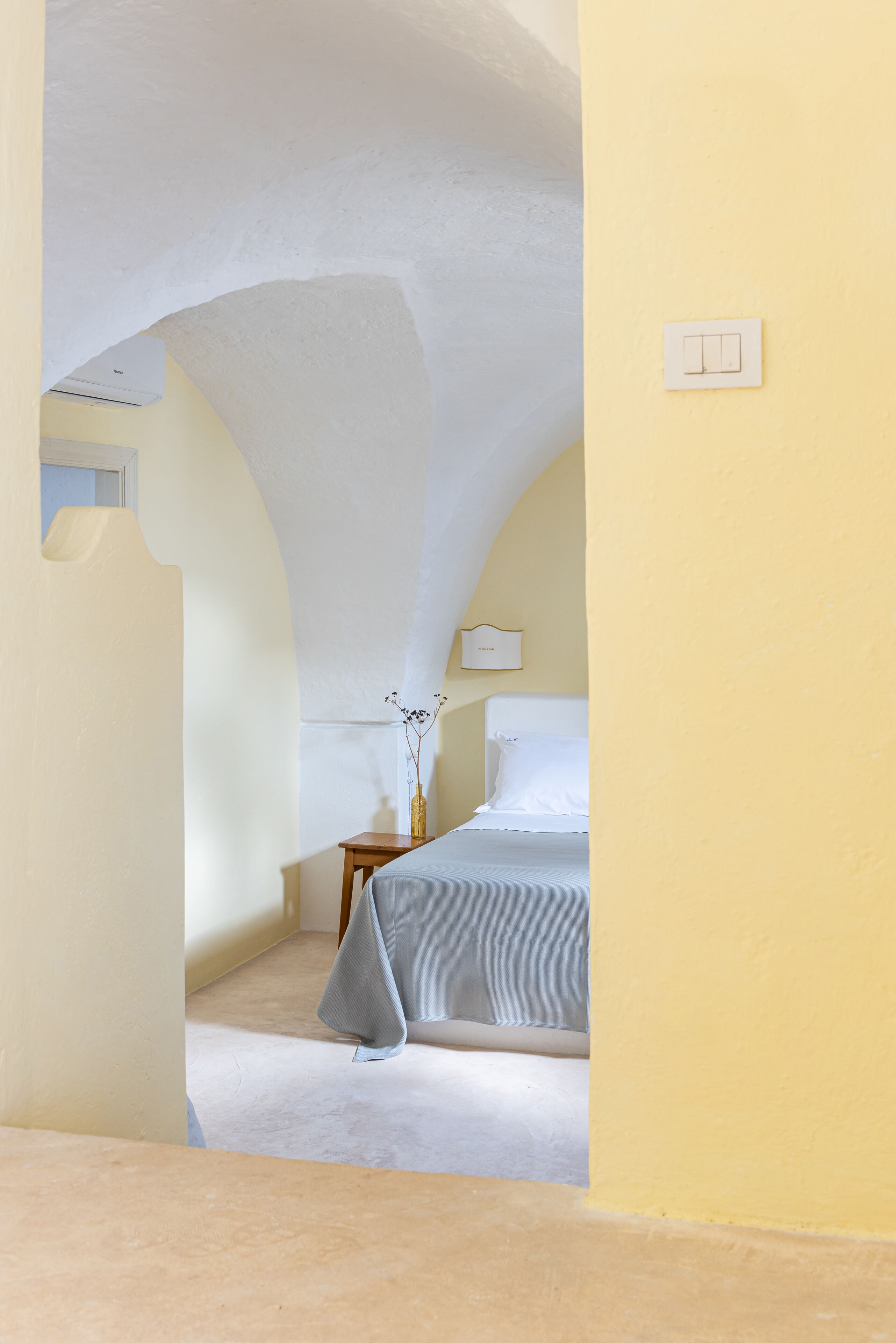 Une chambre à coucher avec un lit, une table de chevet et une lampe.