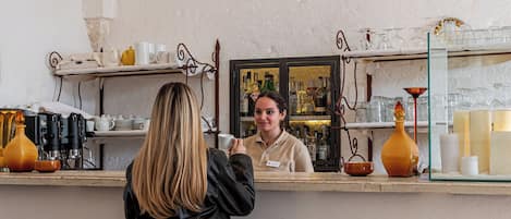 Zona de bar con taburetes, una barra y una lámpara colgante.