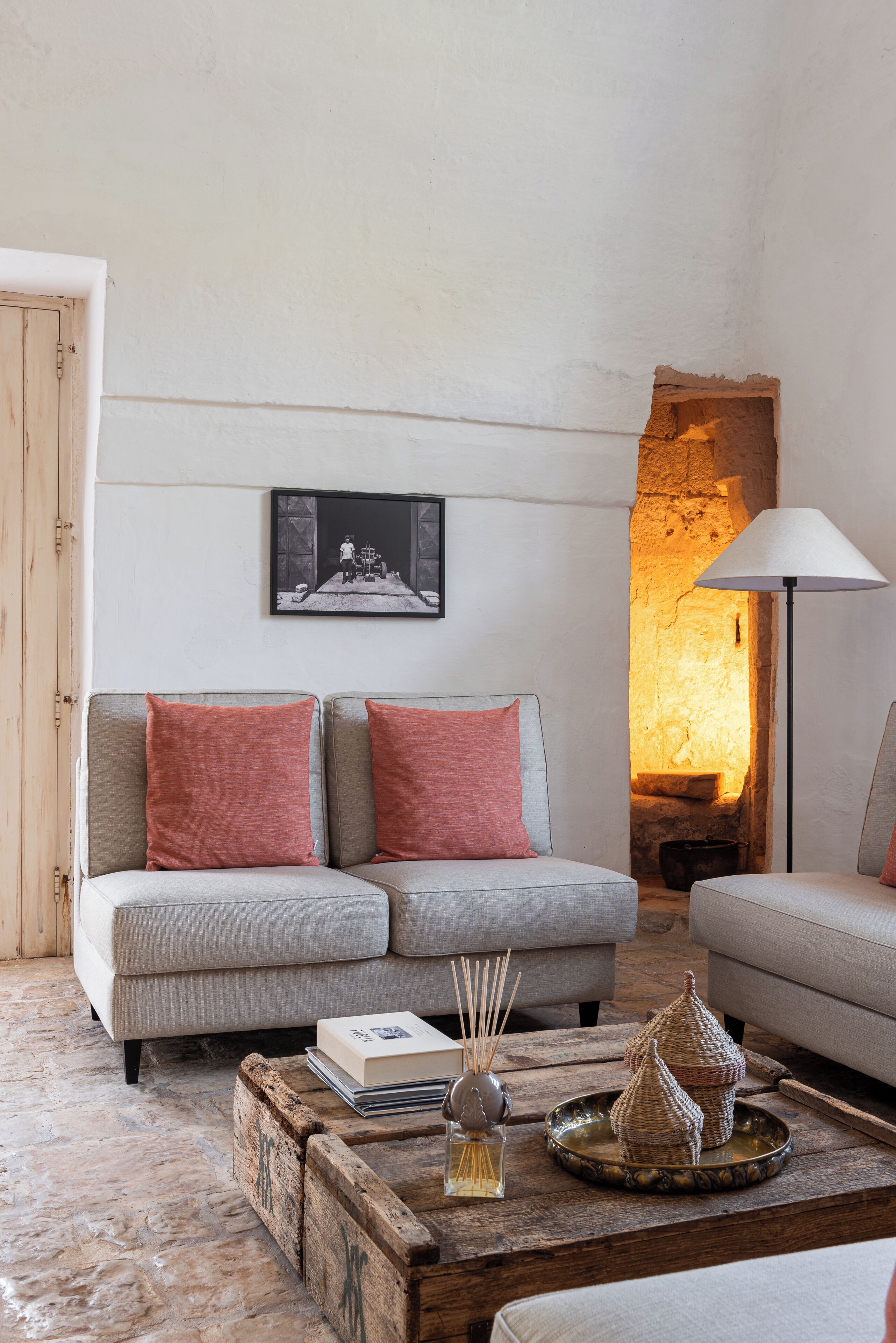 Un salon chaleureux avec un mur en pierre, une cheminée et un ensemble de meubles modernes.