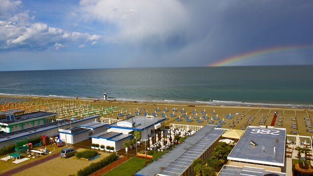 Un hôtel situé en bord de mer, doté d’un grand parking, de parasols de plage et offrant une vue sur l’océan.