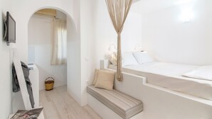 A minimalist bedroom with a bed, a bench, and a decorative hanging. - Porto Vlastos (Tinos)