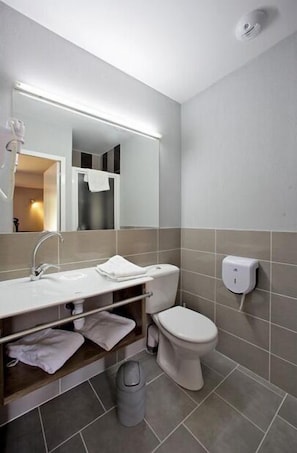 Een moderne badkamer met een wit wastafel, spiegel en toilet.