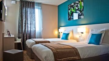 Une chambre d’hôtel avec deux lits, un bureau, une chaise, une télévision et un tableau au mur.