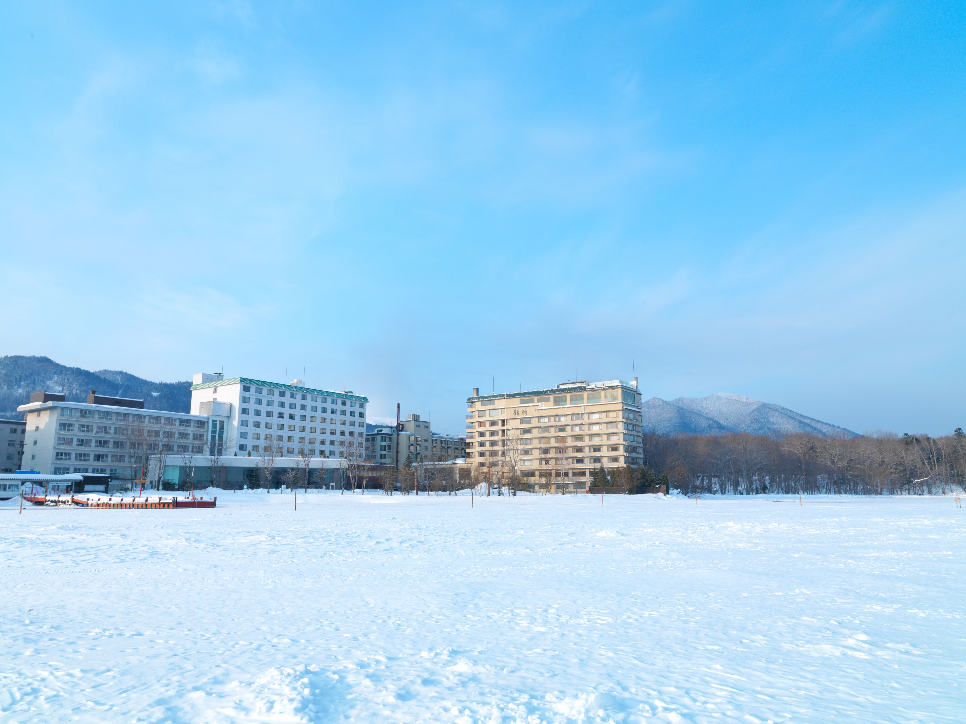 A snow-covered landscape with buildings in the background.
