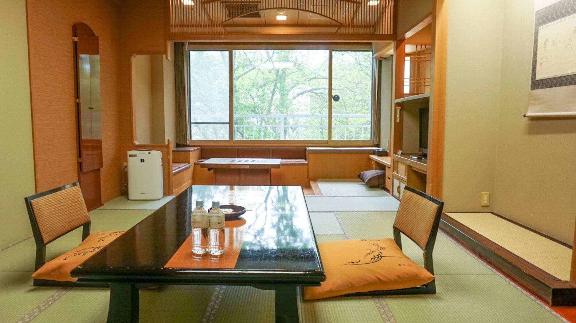 A traditional Japanese-style room with tatami flooring, a low table, and shoji screens.