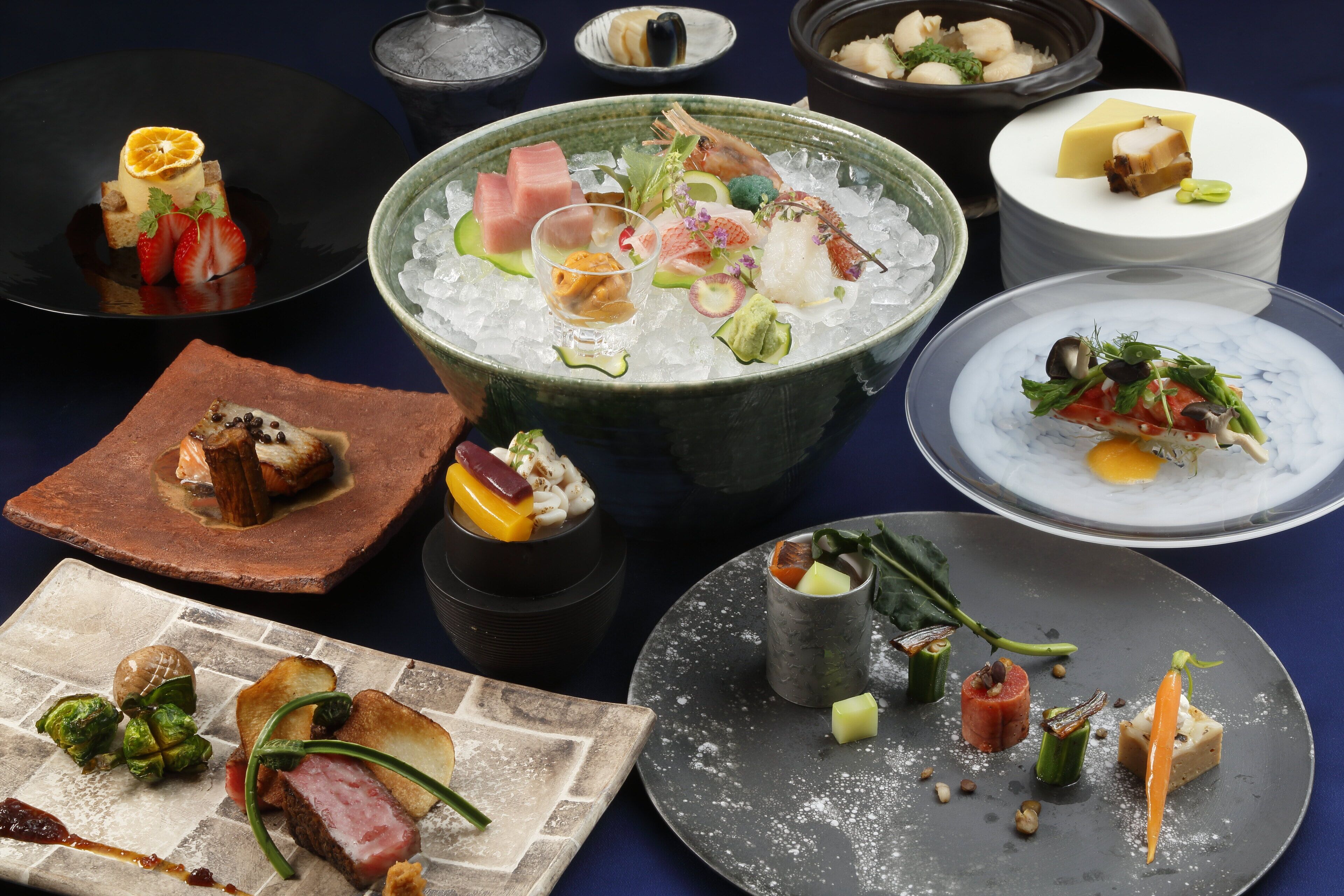 Una variedad de platos en una mesa, incluyendo mariscos, verduras y postres.