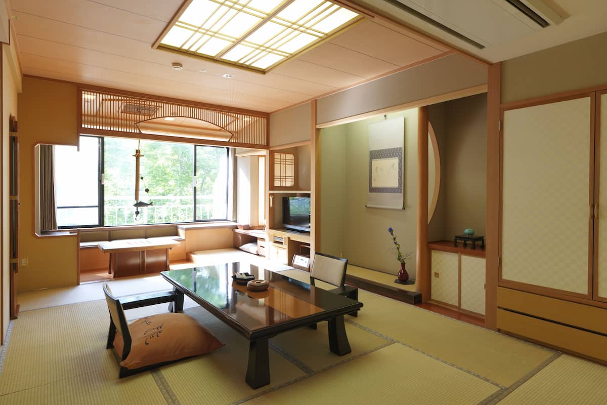 A traditional Japanese-style room with tatami flooring, a low table, and sliding doors.