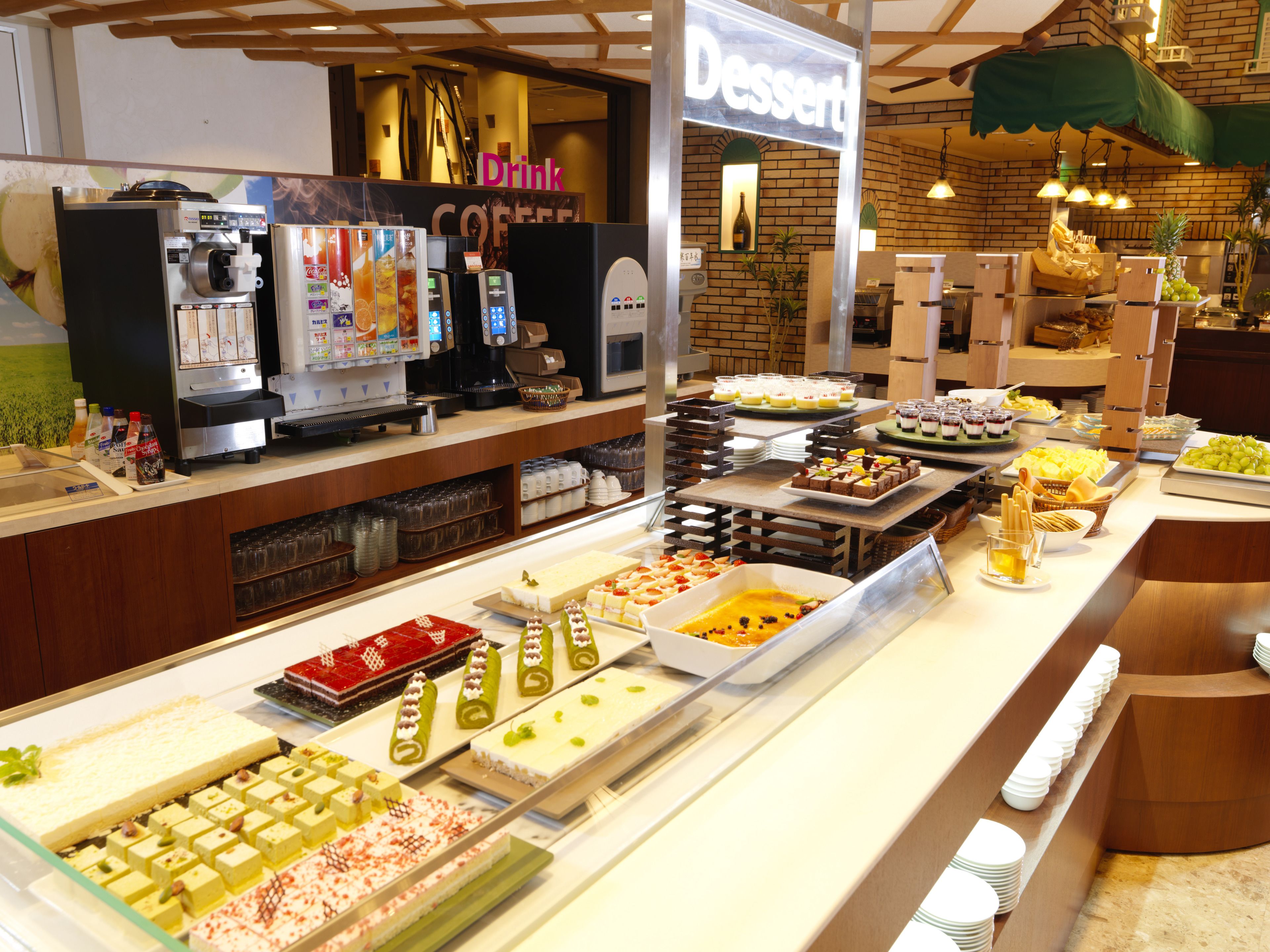 A buffet area with various desserts and beverages, including a coffee station and a drink station.