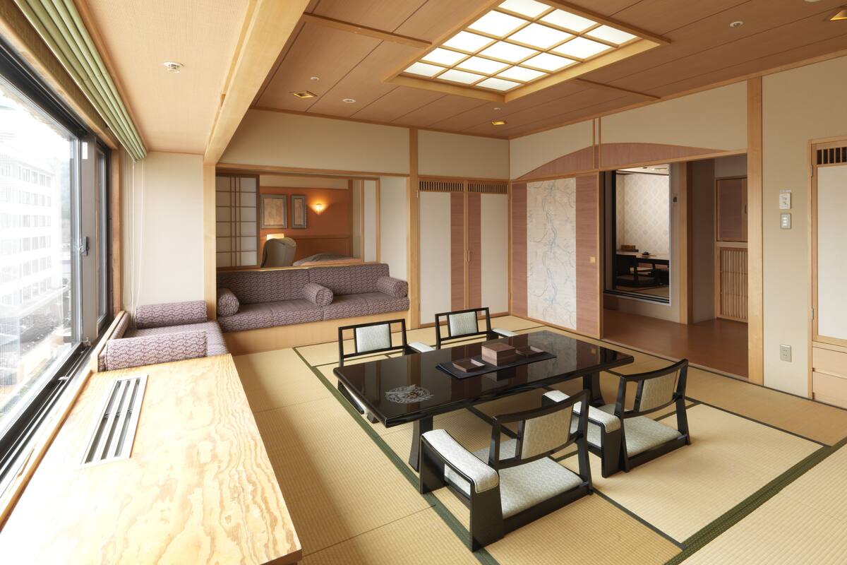 A traditional Japanese-style room with tatami flooring, a low table with cushions, and sliding doors.
