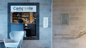 Ein Hotelrestaurant mit Empfangstresen, Sitzgelegenheiten und einer Schilder mit der Angabe der Anzahl der Etagen und Zimmernummern.