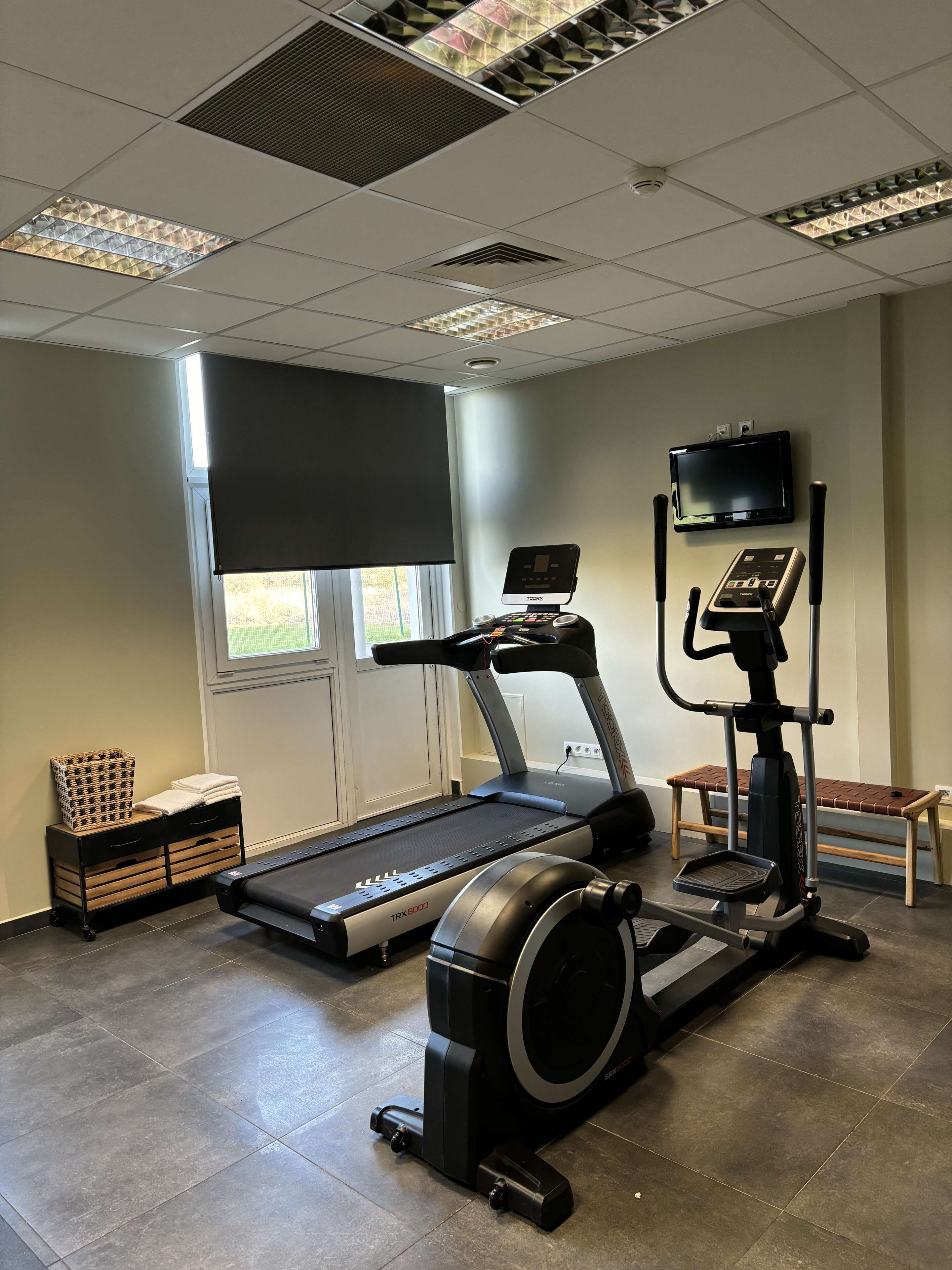 A fitness room with a treadmill, elliptical, and stationary bike.