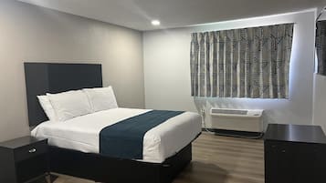 A modern bedroom with a bed, bedside tables, a heater, and patterned curtains.