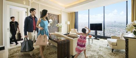 Habitación de hotel con un ventanal grande, un sofá, un televisor y una decoración de pared.