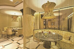 Ein luxuriöses Zimmer mit einem runden Tisch, eleganten Stühlen und einer dekorativen Kristallleuchter.