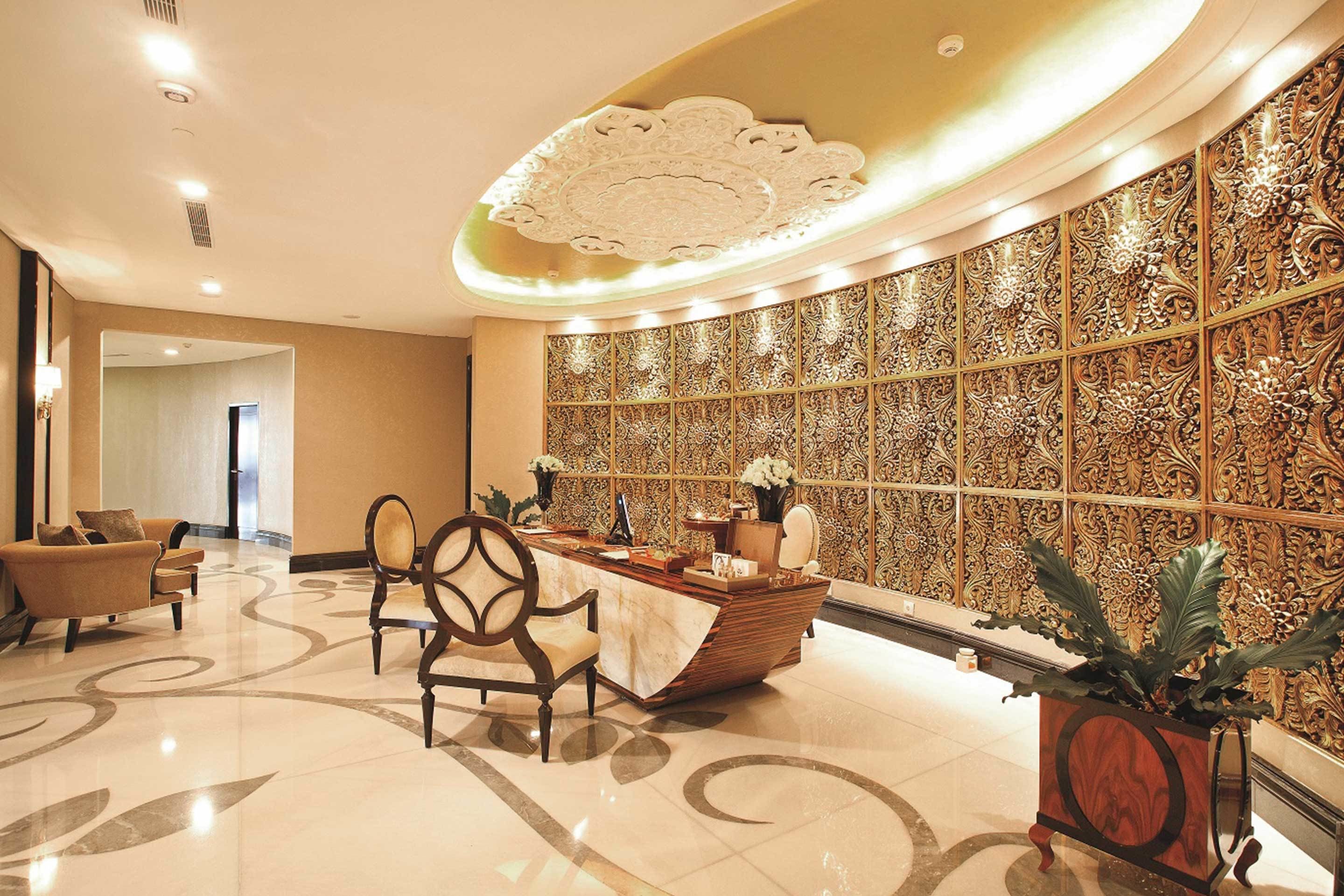 A lobby with a reception desk, seating area, and decorative wall panels.