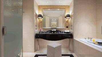 Une salle de bain moderne avec un grand miroir, un meuble-lavabo noir, une baignoire et une cabine de douche en verre.
