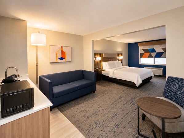 A hotel room with a bed, a sofa, a desk with a sink, and a chair. - Holiday Inn Express Hotel & Suites Truth or Consequences by IHG (Truth or Consequences)