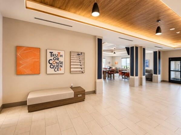 A spacious lobby with a wooden ceiling, a bench, and artwork on the walls. - Holiday Inn Express Hotel & Suites Truth or Consequences by IHG (Truth or Consequences)