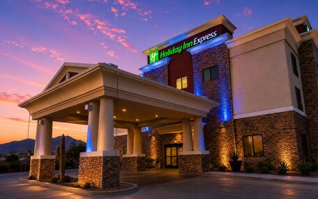 A Holiday Inn Express hotel with a covered entrance, stone facade, and a sign indicating the name.