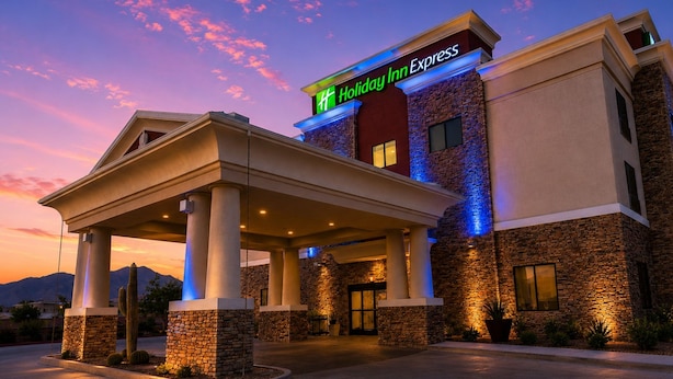A Holiday Inn Express hotel with a covered entrance, stone facade, and a sign indicating the name.