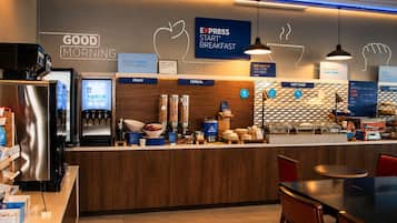 A breakfast area with a coffee machine, fruit bowl, cereal containers, and a sign for Express Start® Breakfast.
