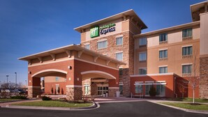 A Holiday Inn Express building with a brick facade, multiple windows, and a clear sky. - Holiday Inn Express and Suites Overland Park by IHG (Overland Park)