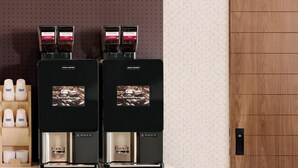 A coffee station with two espresso machines, a coffee dispenser, and a cup holder with disposable cups. - Holiday Inn Express and Suites Overland Park by IHG (Overland Park)