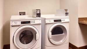 Two front-loading Whirlpool washers with digital displays, a control panel, and a coin return slot. - Holiday Inn Express and Suites Overland Park by IHG (Overland Park)