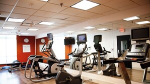 A gym with multiple exercise machines, a treadmill, and a mirrored wall. - Holiday Inn Express and Suites Overland Park by IHG (Overland Park)